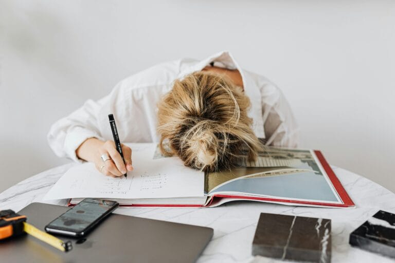 A writer’s desk with crumpled papers and red marks on a draft, representing common mistakes to avoid when writing short stories.