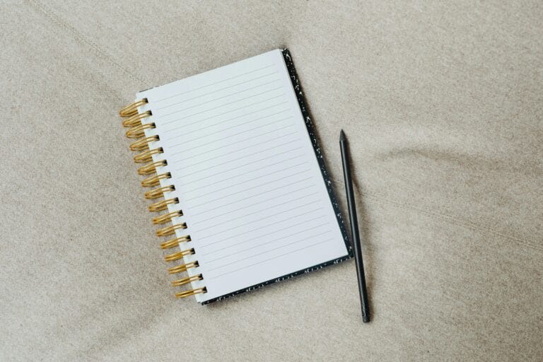 A blank notebook with a pencil and story idea prompts, symbolizing the creative starting point for beginner writers