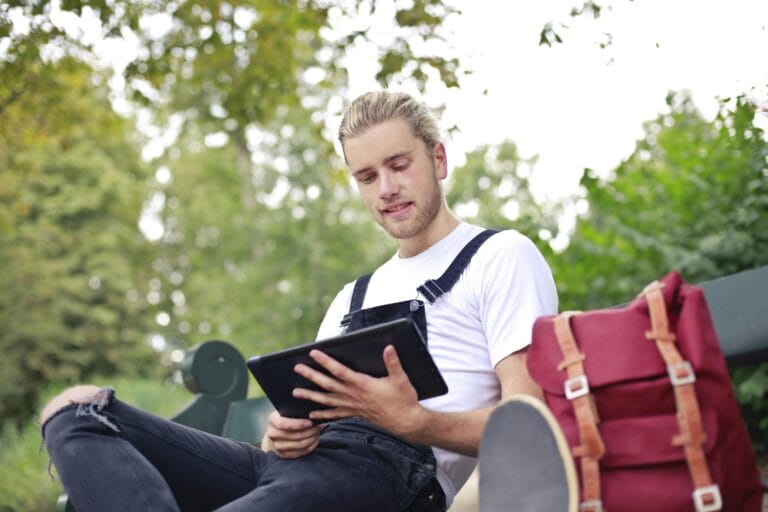 A person reading a short story on a tablet with a clock in the background, symbolizing reading time for short stories.